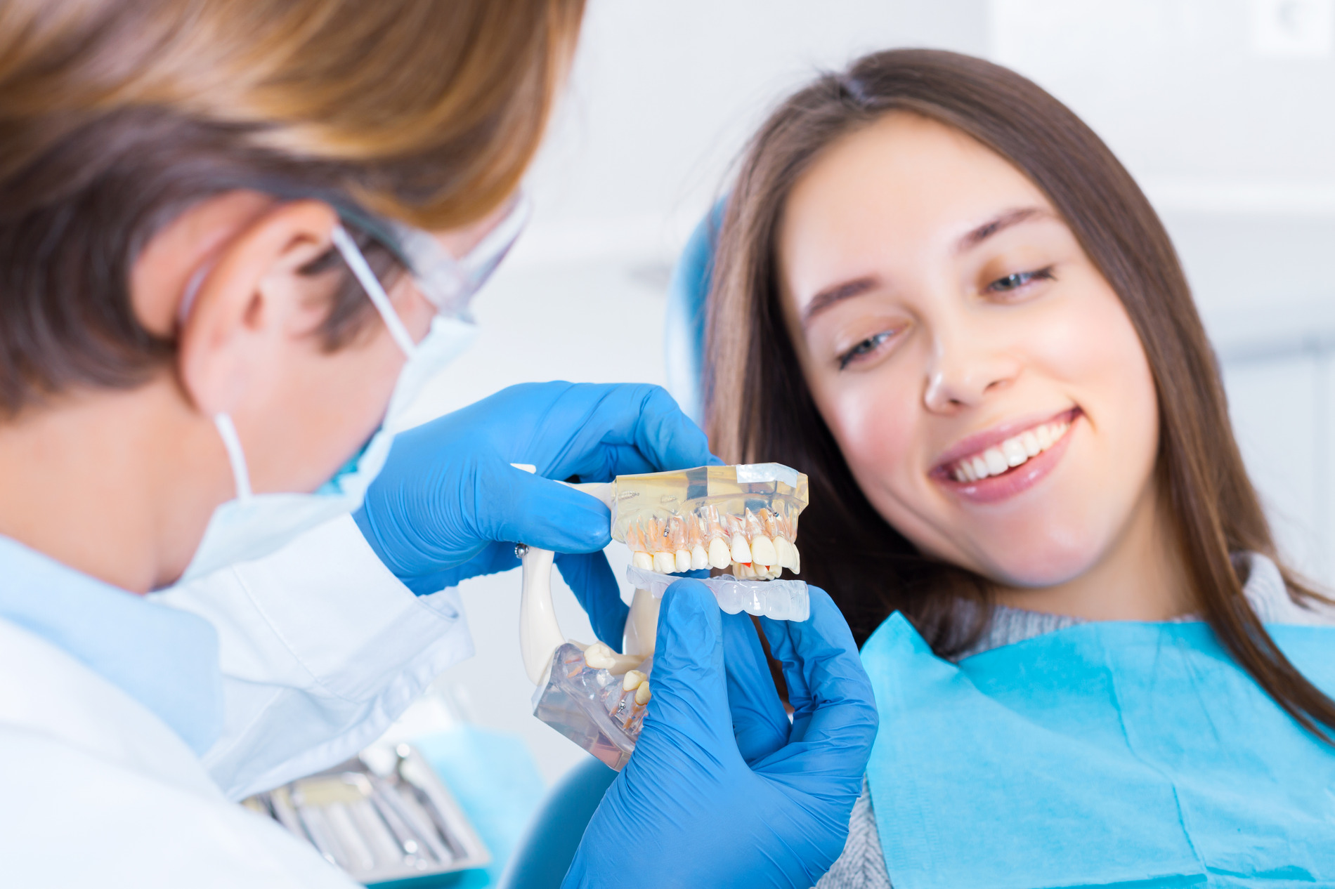 Dentist demonstrates dental mouth gaurd to a smiling woman in Fargo ND