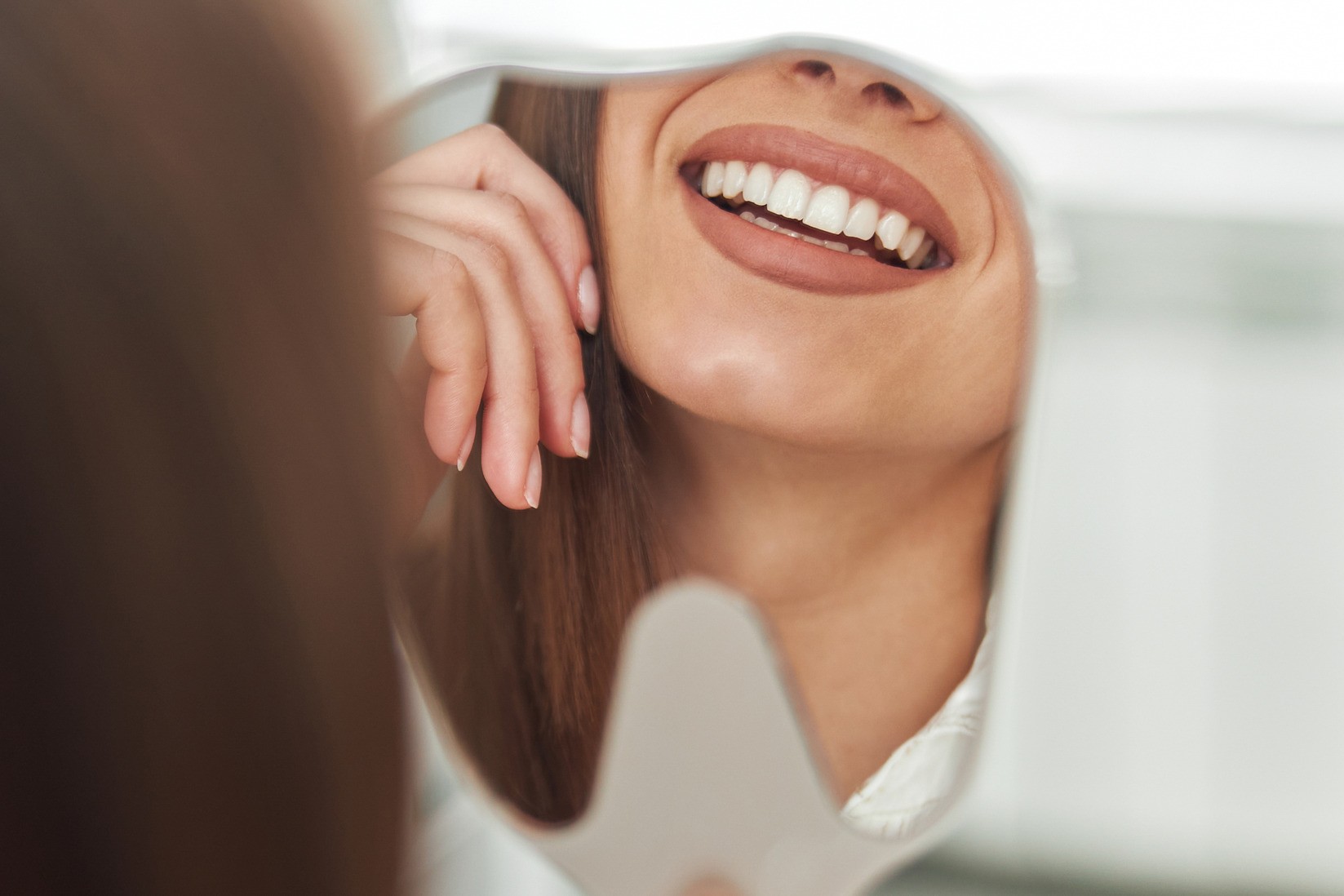 Woman looking at her new smile design from Dr. West-Roehl in Fargo ND